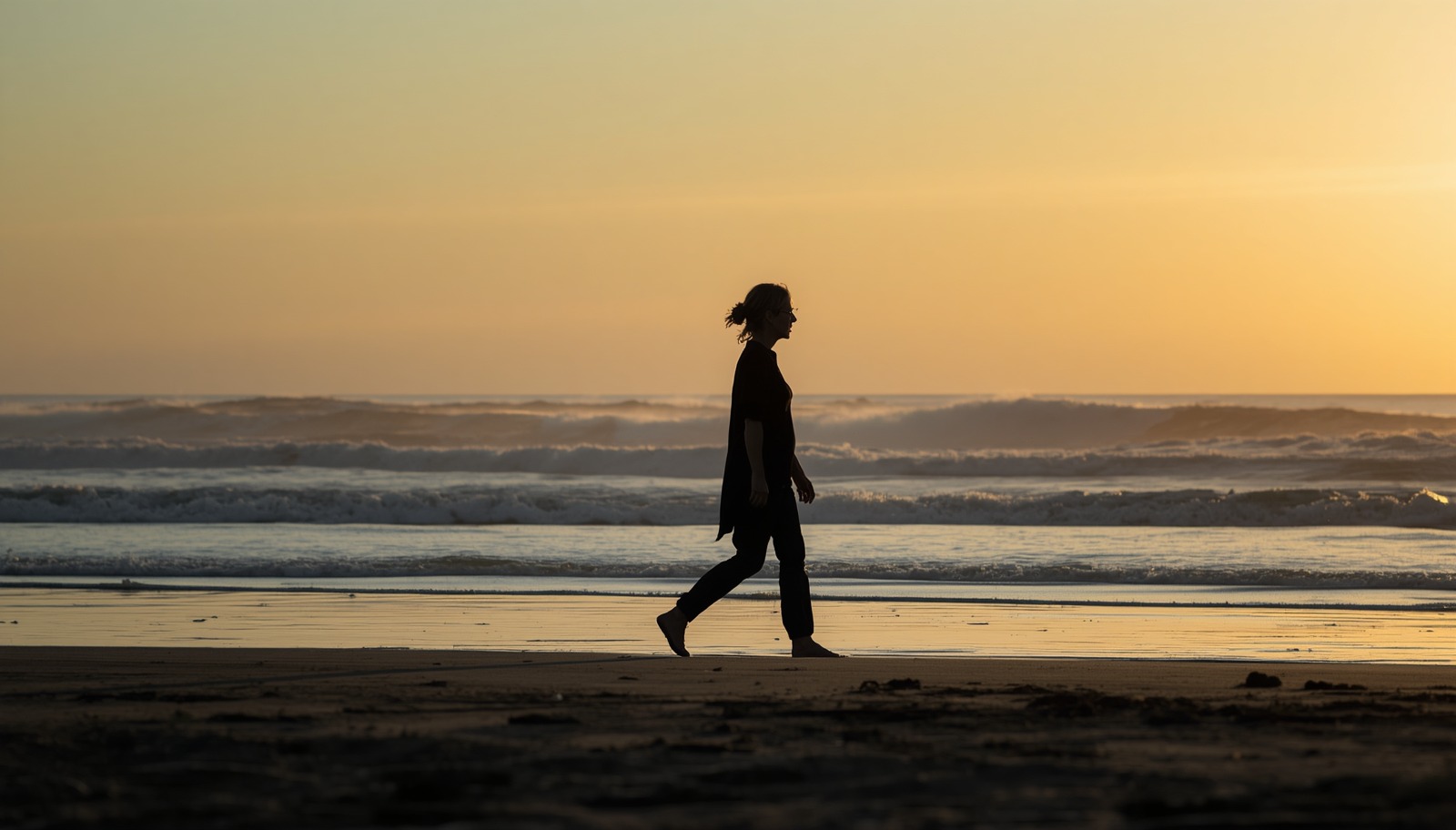 A woman walking thoughtfully beside the sea